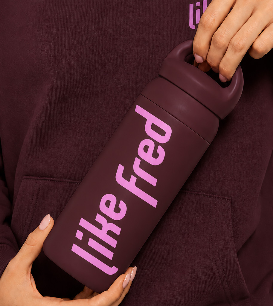 Like Fred branded drink bottle held by a member in a maroon hoodie